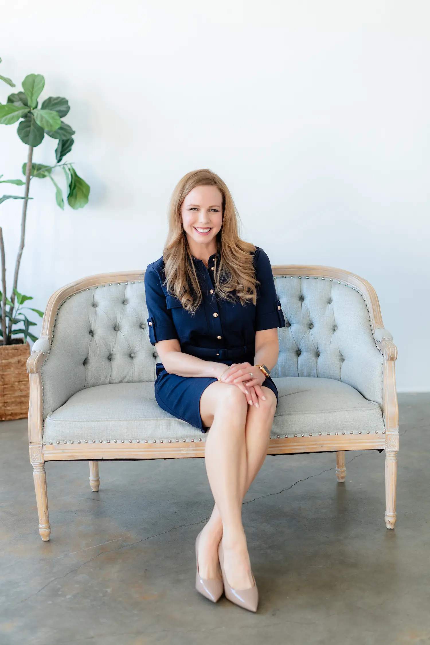 Heather Siegel is a Denver web designer. She has red hair, blue eyes, is wearing a navy blue dress and is sitting on a light blue sofa.